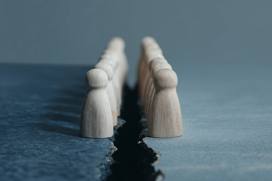 Opposing wooden figurines face each other across symbolic crack representing division.