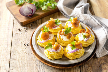 Potato tartlets filled with cottage cheese and marinated mushrooms on a rustic background.