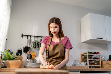 Asian young beautiful woman maid housewife cleaning kitchen at home. 