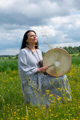 Portrait of a middle-aged shaman woman among yellow flowers