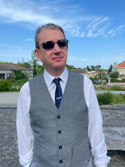 Homme &eacute;l&eacute;gant portant des lunettes de soleil posant en ext&eacute;rieur