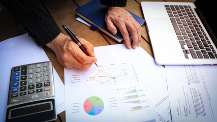 Busibessman hand reviewing a Business Report document and contract investment professional document agreement in the office