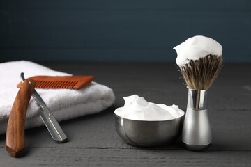 Different barber's tools on grey wooden table, closeup