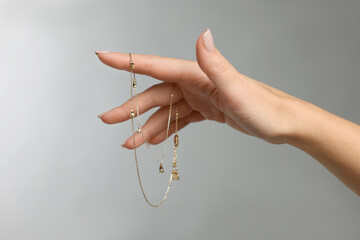 Woman with stylish necklace on grey background, closeup