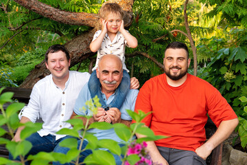 Fototapeta premium Happy male family members smiling together in summer garden