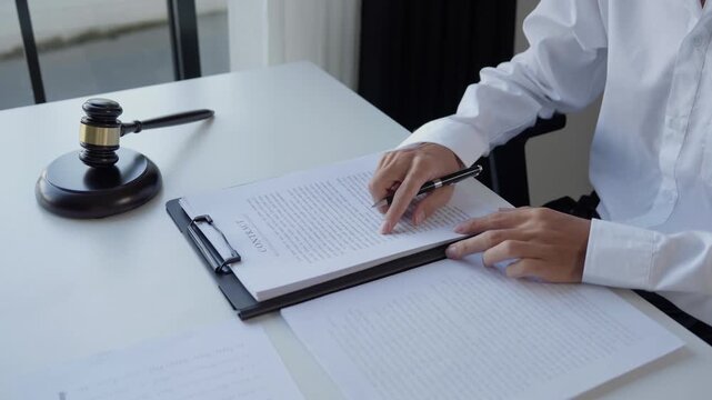 Professional Lawyer Reviewing Lawbook with Gavel at Office or Courtroom Desk