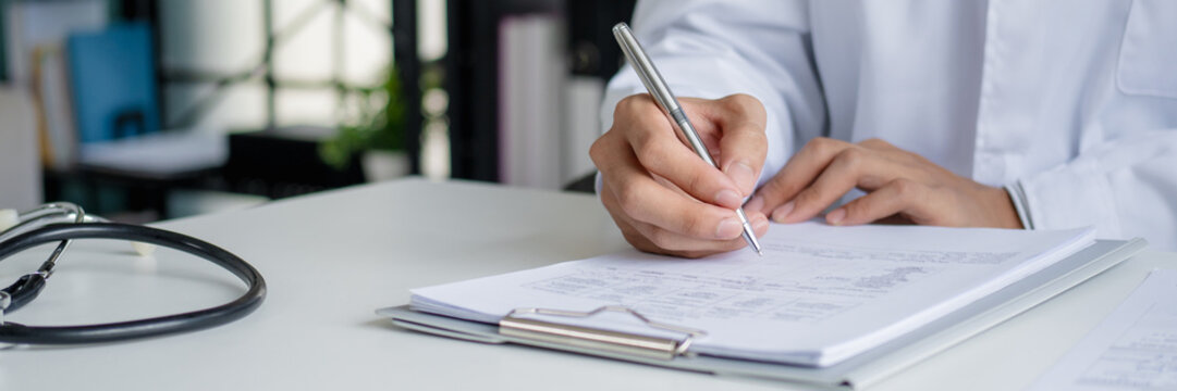 doctor manages medical record documents at a hospital consultation desk