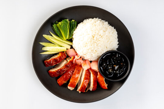 Barbecue roasted duck on rice in the black plate on a white background