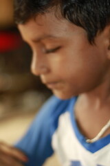 Close-up view of a young child eating homemade food, with small bits of food around the mouth,  innocence of childhood mealtime and the emotional bond of being lovingly fed by a caring hand.