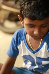 Close-up view of a young child eating homemade food, with small bits of food around the mouth,  innocence of childhood mealtime and the emotional bond of being lovingly fed by a caring hand.