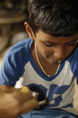 Close-up view of a young child eating homemade food, with small bits of food around the mouth,  innocence of childhood mealtime and the emotional bond of being lovingly fed by a caring hand.