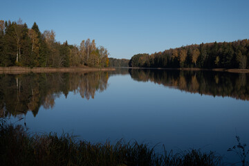 colorful autumn landscape with calm water surface, colorful reflections