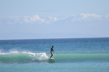 Surfer riding wave on a longboard enjoying ocean sport