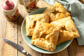 Puff pastry patties with mushroom and cheese filling on a rustic background.