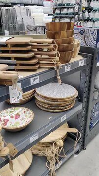 Royan, France - September 24, 2025: La Foir'Fouille, Royan. Wooden cutting boards and serving platters displayed on shelves in a kitchenware store, camera pans across the scene. Editorial use for