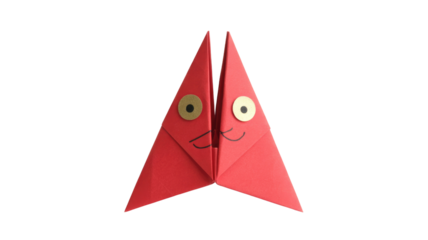 Cute red origami figure with two golden eyes and a cheerful smile, crafted from folded paper against a green backdrop. background removed