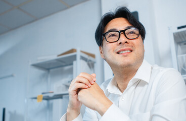 Business Vision and Goal Achievement Business man. Asian Businessman, male manager sit in office looking up with smiling and confident expression with copy space. Portrait of businessperson.