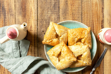Puff pastry patties with mushroom and cheese filling on a rustic background. Top view.