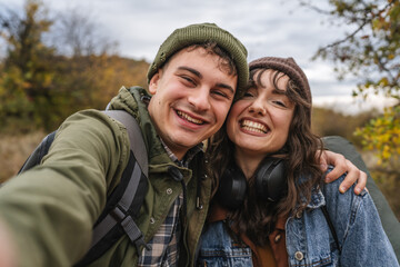 Happy young couple taking selfie while hiking in nature