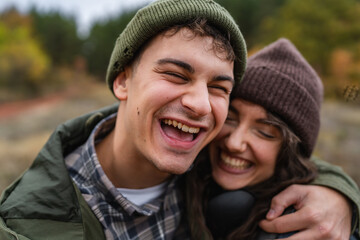 Happy young couple embracing and laughing outdoors