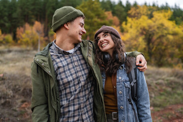 Fototapeta premium Young couple enjoying autumn hike, guy pointing finger