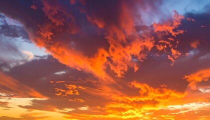 Fiery clouds ablaze in a dynamic sunset sky, a painterly blend of orange, red, pink, and blue hues