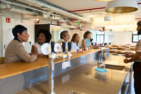 Diverse business professionals networking during coffee break in office