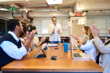 Business team applauding speaker after successful meeting presentation