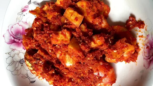 close up of hot spicy shrimp and potato stir-fry served on white plate.