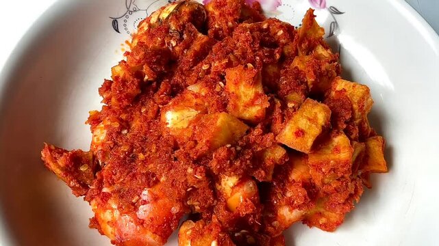 close up of hot spicy shrimp and potato stir-fry served on white plate.