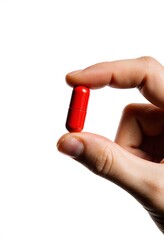 Hand holding a small red pill isolated on pure white background, space for text