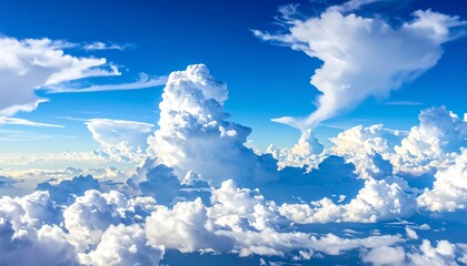 Expansive blue sky filled with fluffy, white cumulus clouds, viewed from above. Sunlight highlights their cottony texture