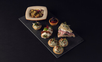 Top view of assorted canapes on slate board