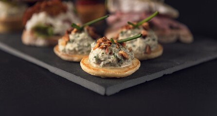 Close-up of gourmet canapé with cream topping and chives