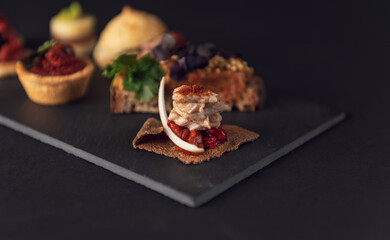 Close-up gourmet canapé with fish and roasted red peppers