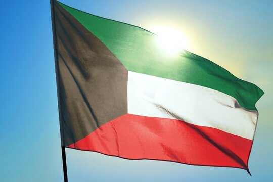 Kuwait national flag waving in sunlight close-up – Kuwaiti tricolor banner green white red with black trapezoid patriotic symbol Arabian Gulf country background blue sky bright sunny day