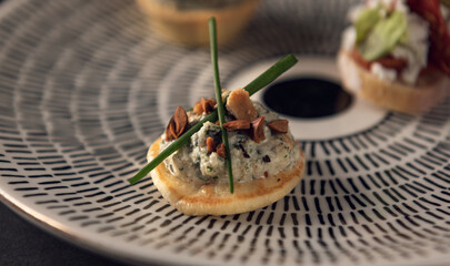 Gourmet canapé with almond cream, herbs and chives