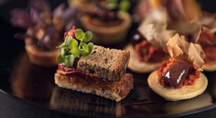 Mini sandwich canapé with sundried tomato and leaf garnish