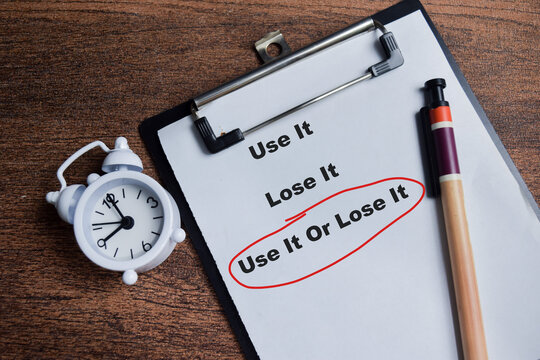 Concept of use it or lose it red circle write on clipboard isolated on Wooden Table. - Powered by Adobe
