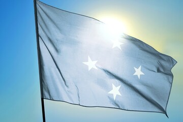 Micronesia national flag waving in sunlight close-up &ndash; Federated States of Micronesia blue banner with four white stars patriotic symbol ocean island nation background blue sky bright sunny day