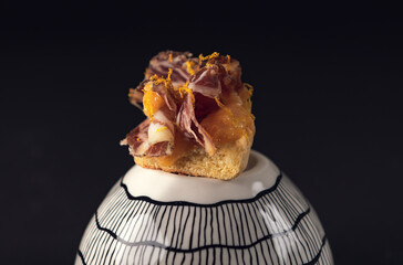 Gourmet bruschetta topped with cured ham and orange zest