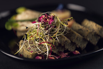 Close-up seed bread slices with microgreens and edible petals