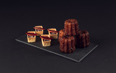 Canelés and assorted tarts arranged for elegant dessert display