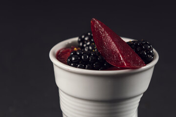 Close up blackberry dessert cup with red fruit gelée