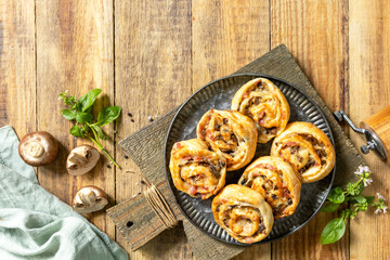 Puff pastry rolls with mushroom and cheese filling on rustic background. Top view.
