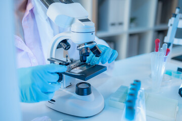 A chemistry researcher in a laboratory surrounded by scientific equipment and test tubes, representing innovation, scientific development, and modern medical research environment.