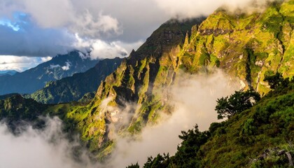 Sunlight illuminates lush green mountain slopes shrouded in mist dramatic clouds form over rugged terrain in a remote wilderness area