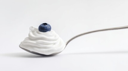 Fototapeta na wymiar Silver spoon with greek yogurt or cream and fresh berry isolated on white background