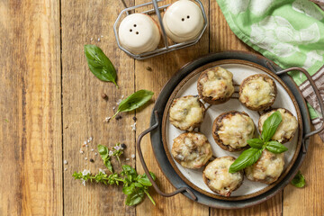 Stuffed mushrooms baked with cheese on rustic background. Top view flat lay background.  