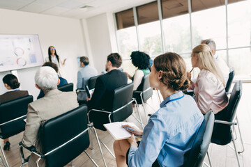 Diverse team of professionals engaged in a business presentation in a modern office setting, fostering collaboration.